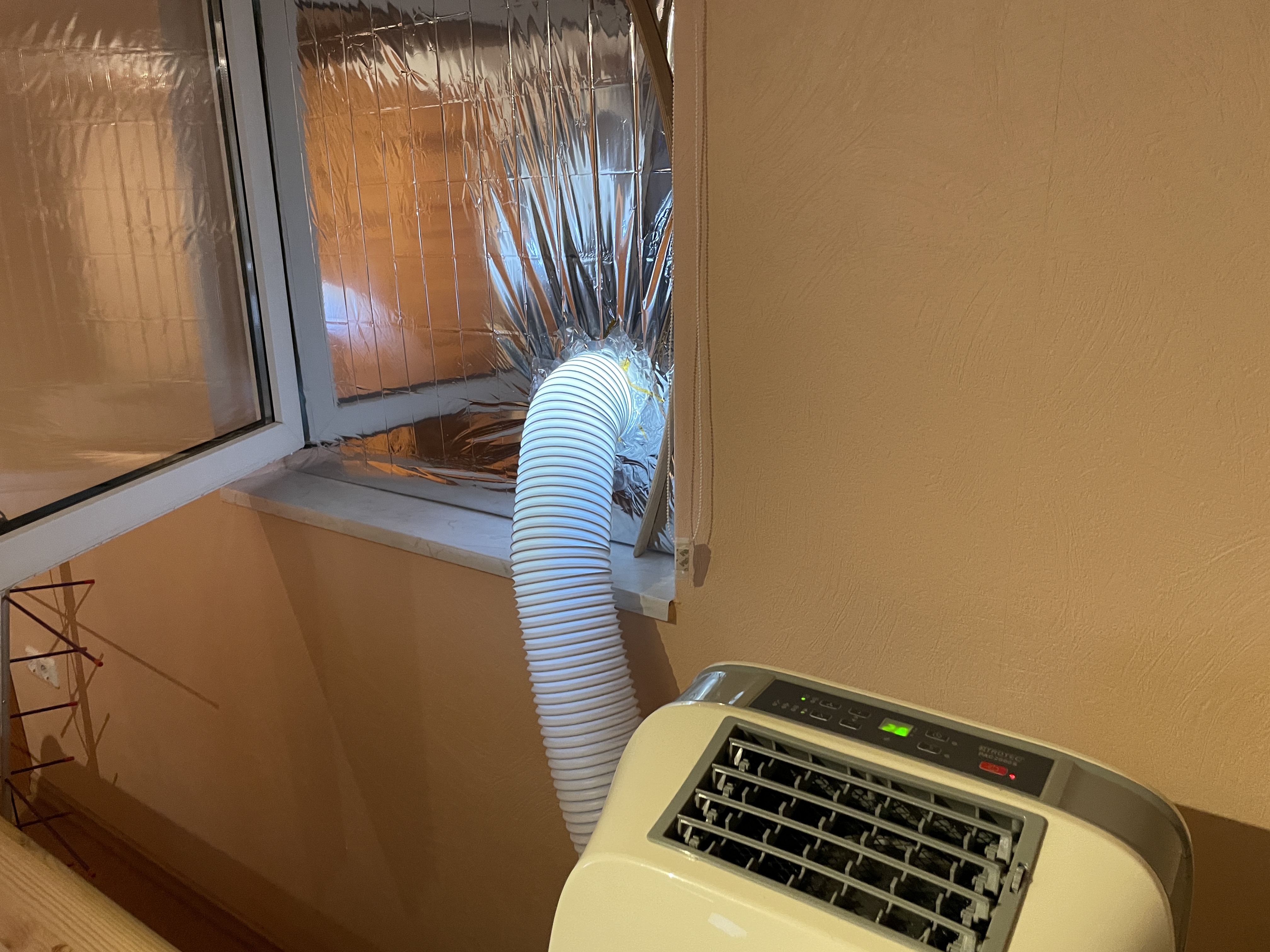 A/C unit connected to a window using a hose