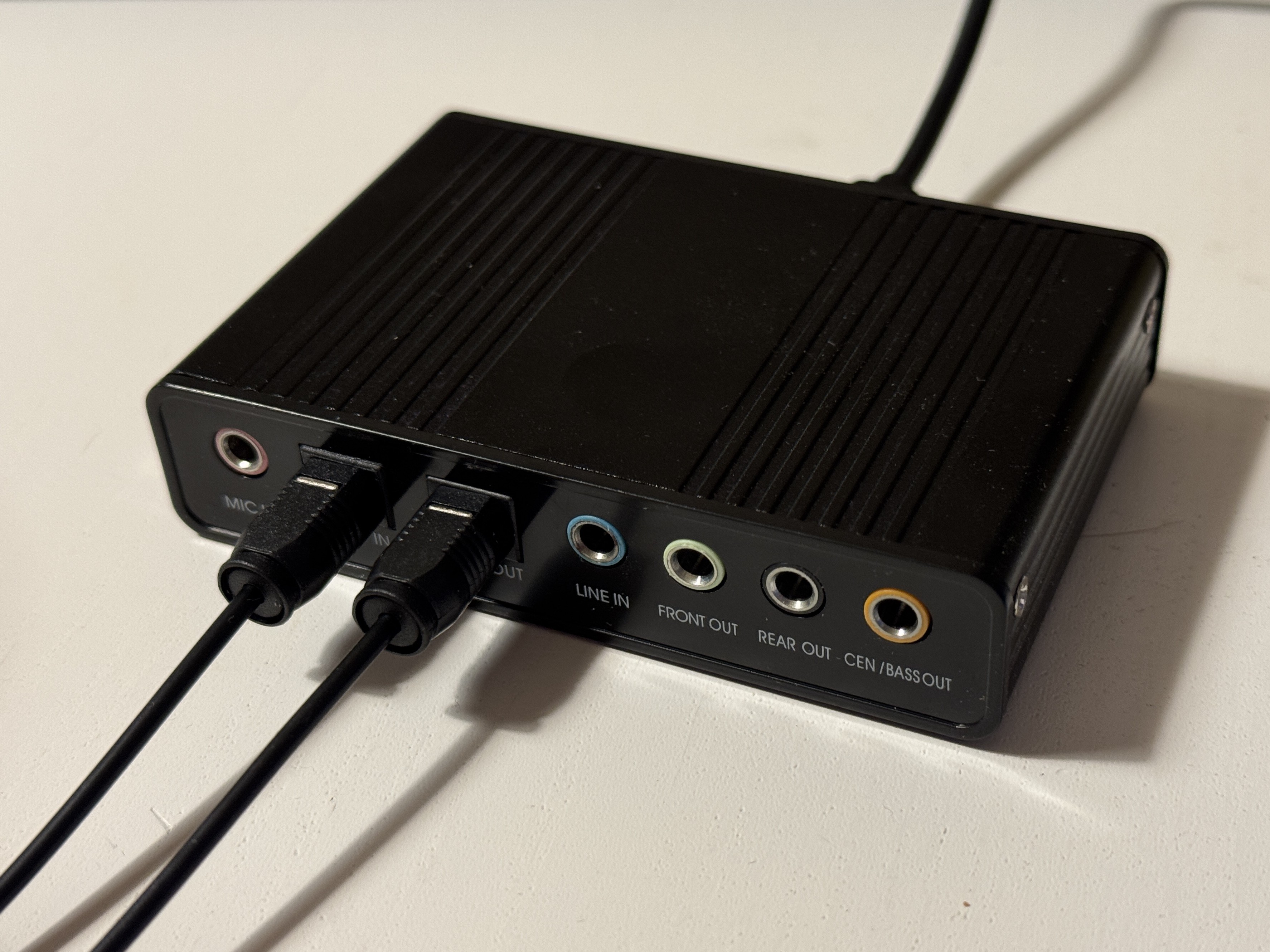 USB sound card, with 5 3.5mm headphone jacks and 2 Toslink ports, cables attached